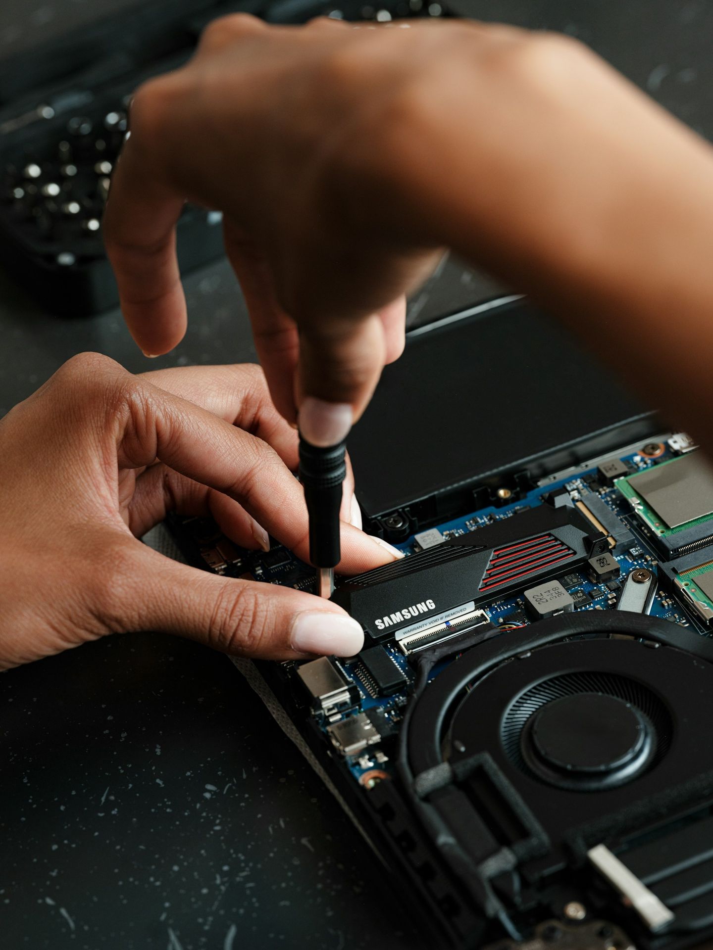 A person working on a laptop with a pen